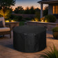 Waterproof round gas fire pit cover on a patio at dusk