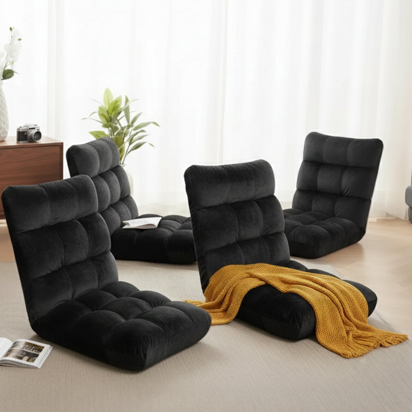 Black floor chairs in a living room setting with a yellow blanket and magazines.