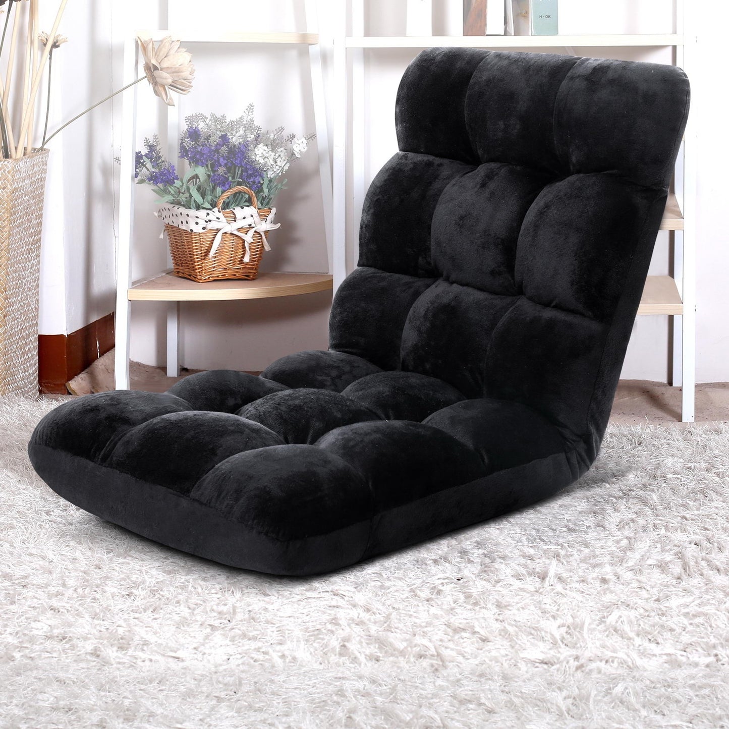 Black cushioned floor chair on a light carpet with a blurred background