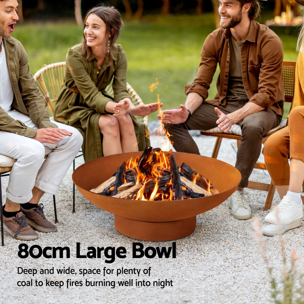 People sitting around a large fire pit bowl in an outdoor setting