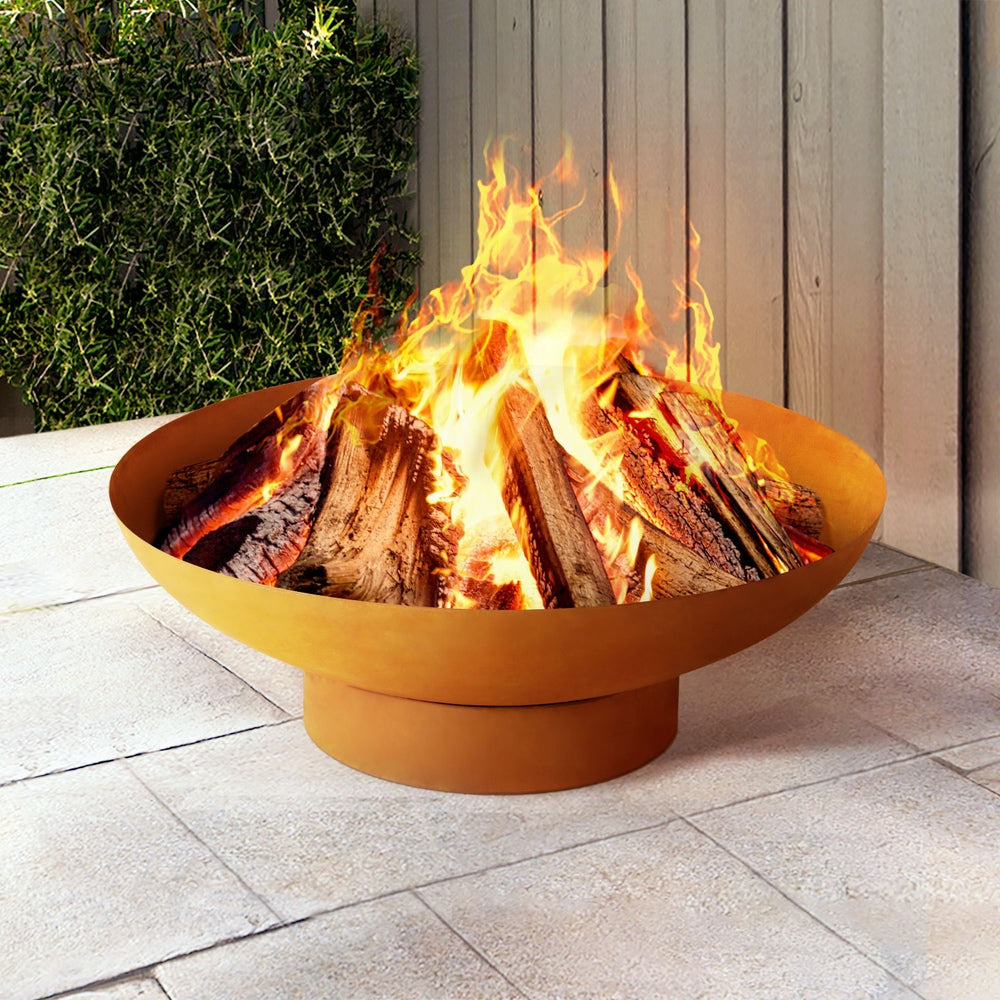 Orange fire pit with flames on a patio