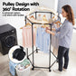 Woman using a clothing rack with pulley design and 360-degree rotation in a laundry room.