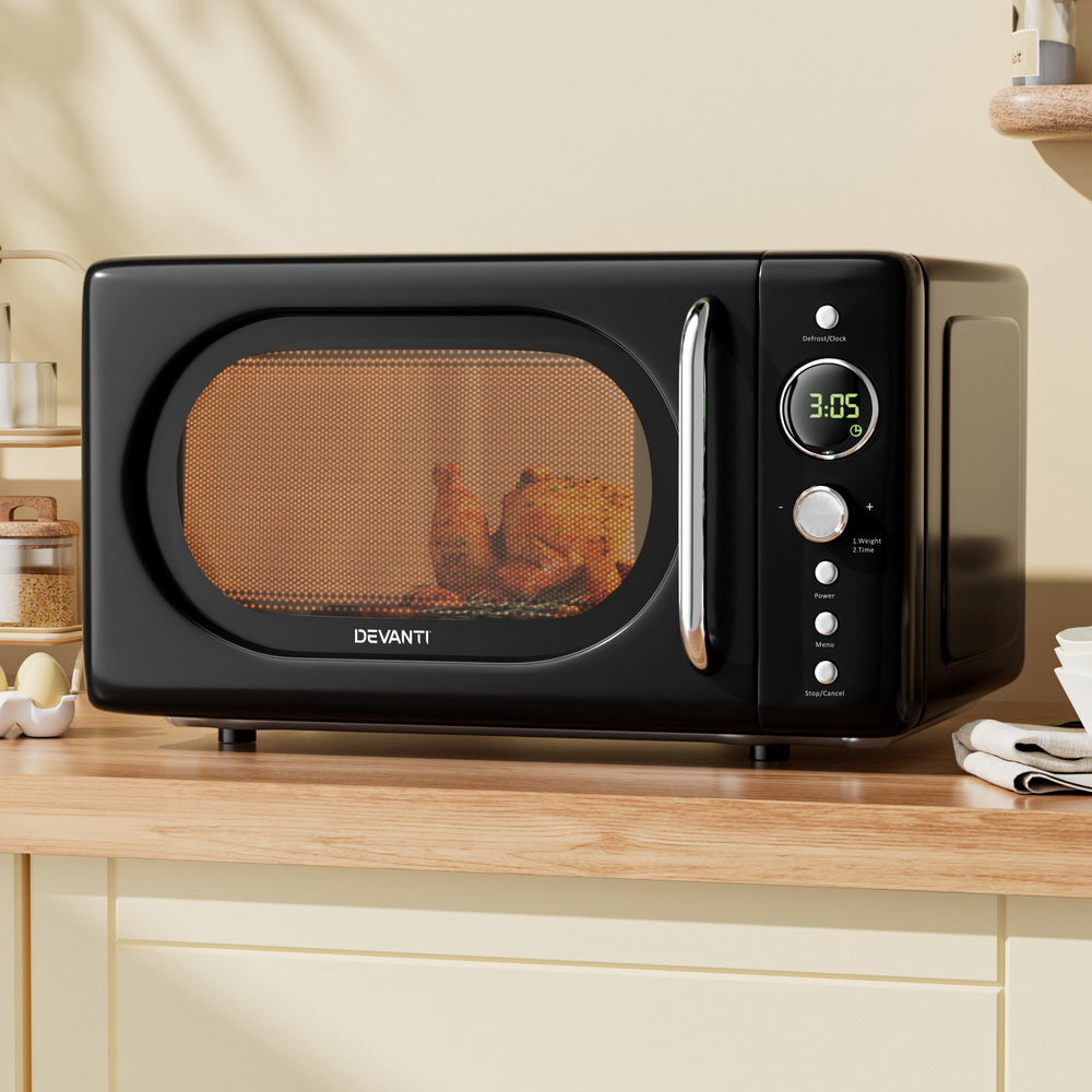 Black Devanti microwave oven on a kitchen counter with food inside