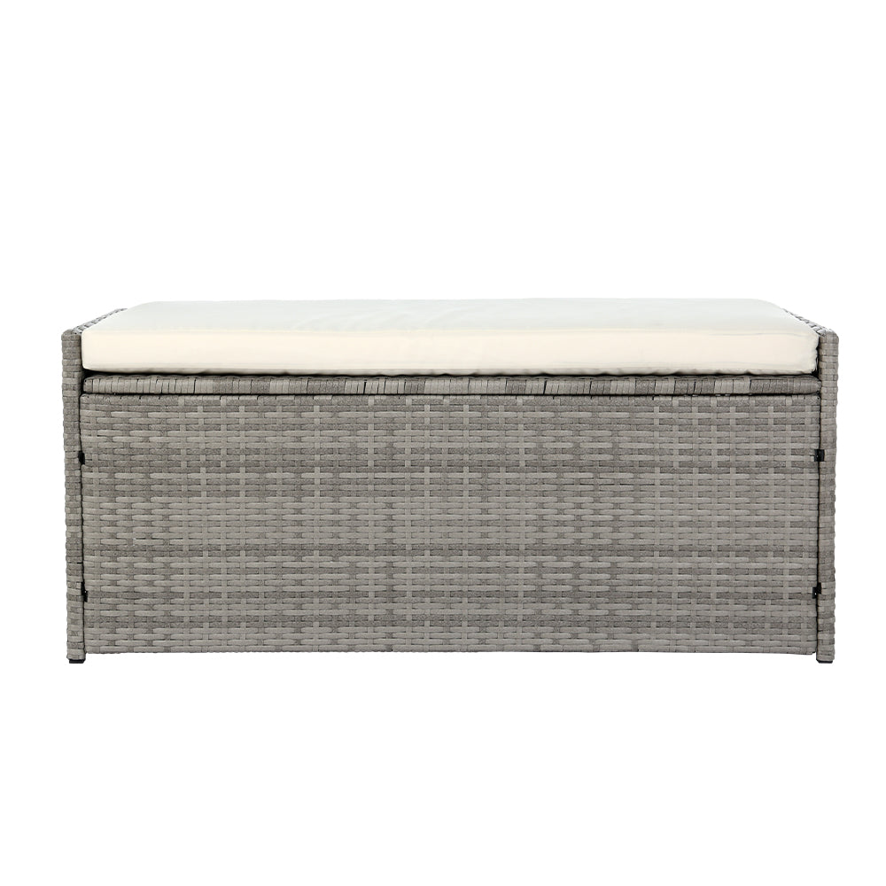 Gray wicker storage bench with a white cushion on a white background