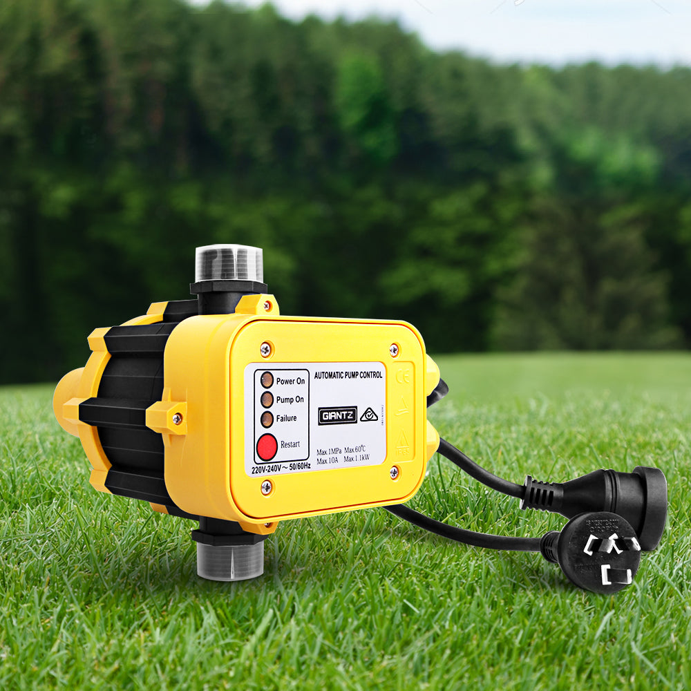 Yellow and black pump control device on grass with blurred greenery in the background