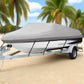 Boat on a trailer with a cover on a beach under a blue sky with clouds.