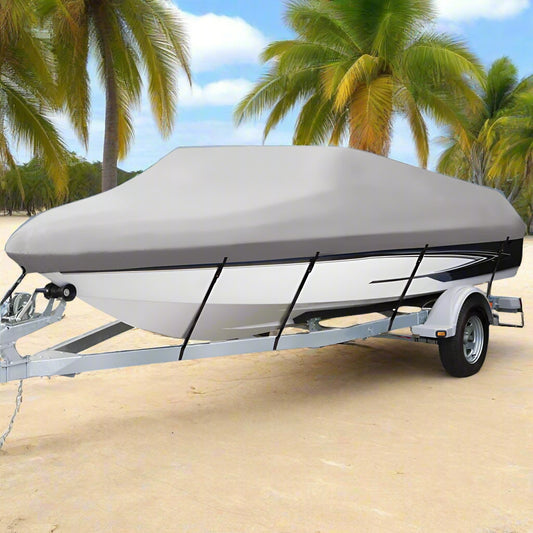 Boat on a trailer with a cover on a beach under a blue sky with clouds.
