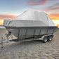 Boat on a trailer with a gray cover on a sandy beach with ocean in the background