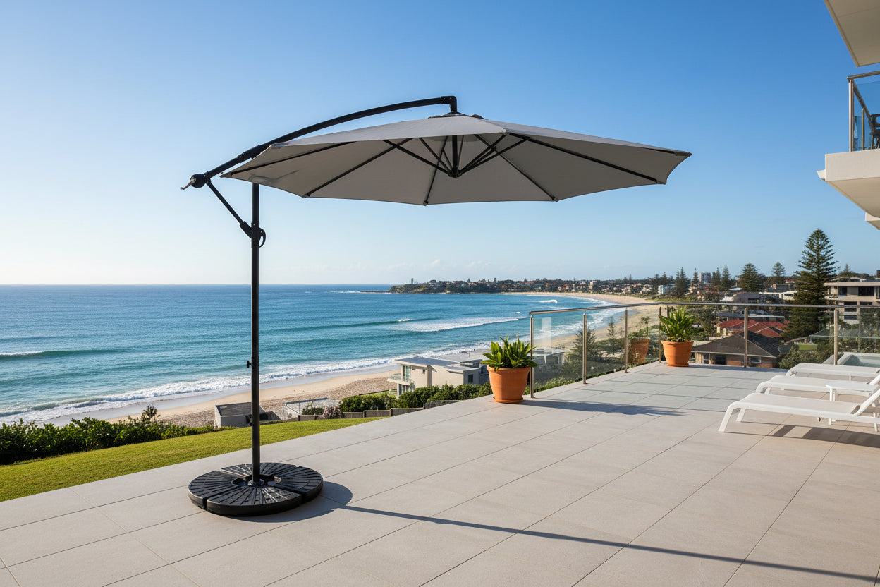 Gray patio umbrella with a black stand on a white background