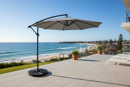 Gray patio umbrella with a black stand on a white background