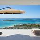Beige patio umbrella with black stand on a white background