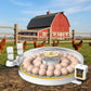 Egg incubator with eggs  with a farm in the background